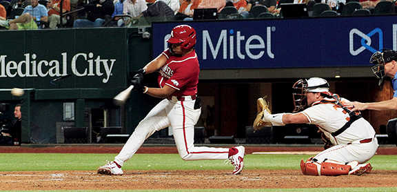 Kendal Diggs swings at a pitch against Texas pitcher Lucas Gordon in the season opener at Globe Life Field.